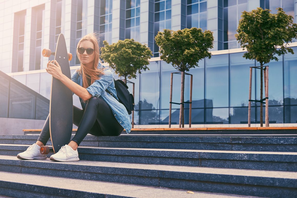 Newslikeyou.com Lifestyle Insights: Trends Shaping Modern Living 4 young hipster blonde girl casual clothes sunglasses sitting steps against skyscraper resting after riding skateboard